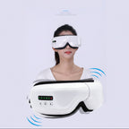 A white and black smart eye massage device is shown both close-up and worn by a woman, with blue vibration graphic accents on a pale background.