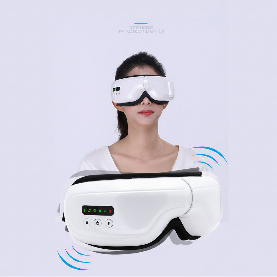 A white and black smart eye massage device is shown both close-up and worn by a woman, with blue vibration graphic accents on a pale background.