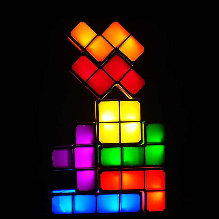 A stack of glowing LED block lights shaped like a Rubik's cube, shown illuminated in multiple colors against a black background.