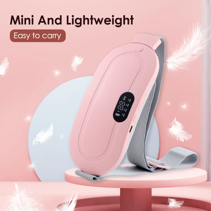 A pink mini electric heating pad with a gray strap, displayed on a pink pedestal with decorative white feathers and a light blue circular prop. Text on the image reads 'Mini And Lightweight' and 'Easy to carry'.